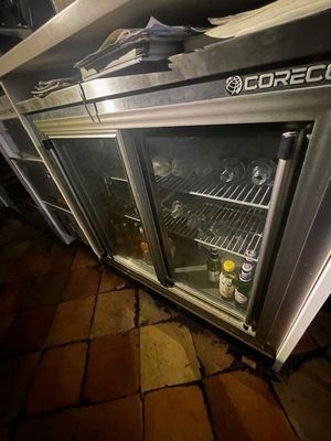 bottles of beer sit inside of a cooler on a brick floor