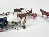 a group of toy horses pulling a carriage with a man on it