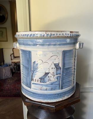 un grand vase bleu et blanc posé sur un socle en bois