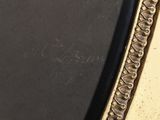 a close up of a gold framed mirror with a black background