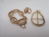 two pieces of gold jewelry on a white surface
