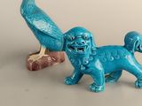 two figurines of a dog and a bird on a table