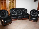 three black leather couches and two chairs in a living room