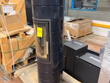 a large black stove sitting on a pallet in a warehouse