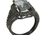an image of a fancy ring with a green stone surrounded by black diamonds