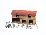 une ferme miniature avec un tracteur et des animaux de la ferme devant