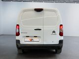 the back of a white van parked inside of a building