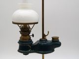 une lampe à huile à l'ancienne, surmontée d'un abat-jour en verre