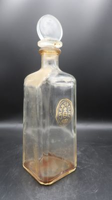 an image of a clear glass bottle with a gold emblem