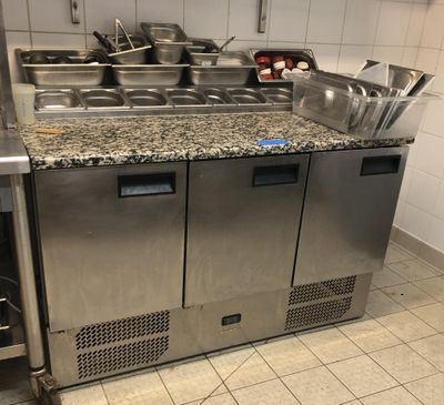 une cuisine équipée d'un évier, d'une cuisinière et d'autres appareils électroménagers