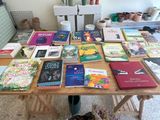 une table sur laquelle sont posés de nombreux livres et un chat allongé sur la table
