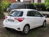 a small white car parked on the side of the road