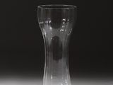 un vase en verre posé sur une table, sur fond noir