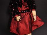 an image of a doll with a red dress and red shoes