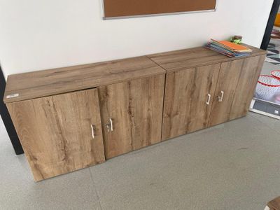 un meuble TV en bois dans une pièce où la télévision est accrochée au mur