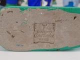 the bottom of a pair of shoes with a green sole