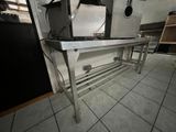 a metal table with a microwave on it in a kitchen