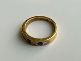 a close up of a gold ring with blue stones on it