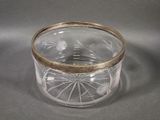 a glass container with a gold rim on a table