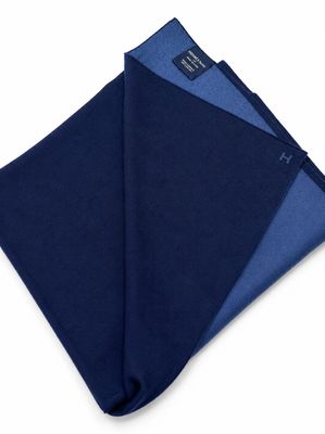 une pochette bleu marine et bleue, pliée sur un fond blanc