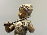 une statue en bronze représentant une femme jouant du violon