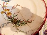 une assiette sur laquelle sont peints des fleurs et un oiseau