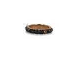 a gold ring with black stones on a white background