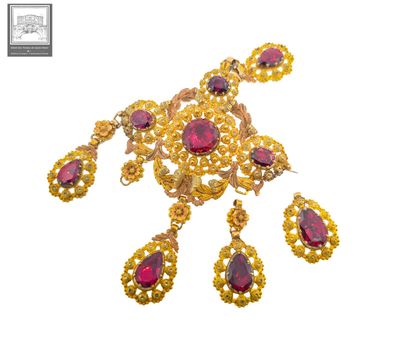 a close up of a gold necklace and earrings with red stones