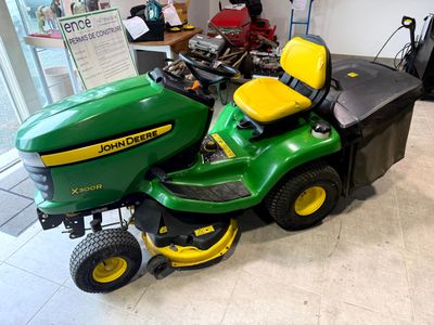a green lawn mower parked in a garage