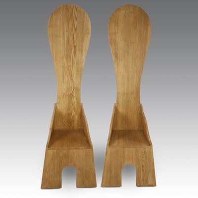 deux chaises en bois placées côte à côte sur un fond gris