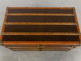 a brown and black striped trunk sitting on a cement floor