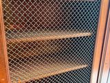 a wooden cabinet with a wire mesh door on it
