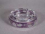 a clear glass ashtray with purple designs on it