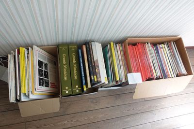 de nombreux livres rangés dans une boîte posée par terre