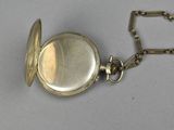 a silver pocket watch with a chain around it