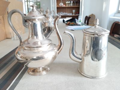 une théière en argent et une cafetière en argent posées sur une table