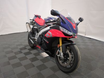 une moto rouge et bleue garée sur un sol à damier noir et blanc