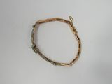 a close up of a gold bracelet on a white surface
