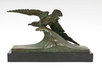 sculpture en bronze représentant deux oiseaux volant au-dessus d'une vague sur fond blanc