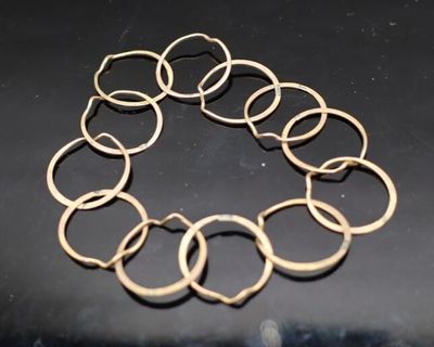 gros plan d'un bracelet en or sur une surface noire