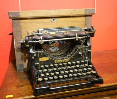 une vieille machine à écrire posée sur une table en bois
