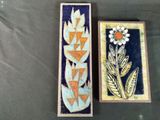 two decorative tiles with flowers on them on a table