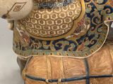 a figurine of a man riding a horse on a barrel