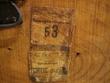une boîte en bois sur laquelle est collée une étiquette indiquant « 53 »