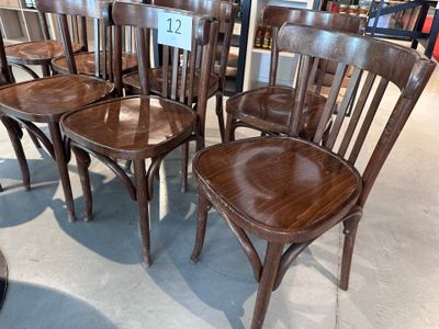 six chaises en bois dans un magasin, avec une étiquette de prix accrochée dessus