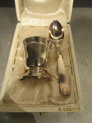 une cuillère en argent et un repose-cuillère dans une boîte