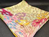 un mouchoir à motifs paisley jaunes et roses sur un fond noir