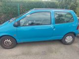 a small blue car parked on the side of the road