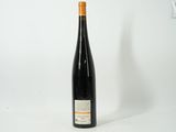 the bottle of wine is sitting on a white surface
