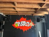 un mur recouvert de graffitis sur lequel figure le symbole « boom »